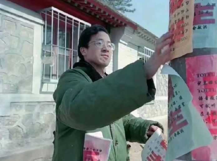 圖十八，一位正在街頭電線杆上貼廣告的人，