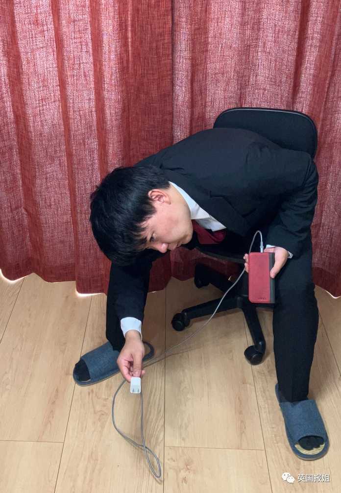 70b7b5a57c5ff8511decda46858f13ebe09ff00a 坐在椅子上伸手去夠桌下插排的人