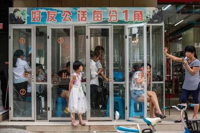 b82634eb27d2e9e4a687fc3afdb0e0faf1f41ead 2016年6月1日,廣東東莞,打工者在電話亭給家人打電話,話費每分鐘一角錢