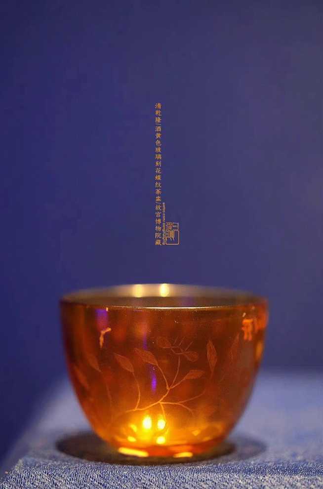 f9493c5b69ce605575e234615ae208e4d6646cce 清 乾隆 酒黃色玻璃刻花蝶紋茶盅