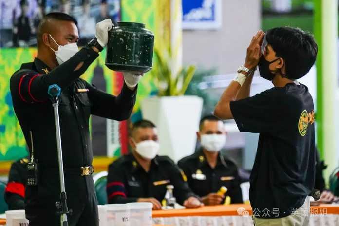 在徵兵現場，一群人在下面排隊等待抽籤